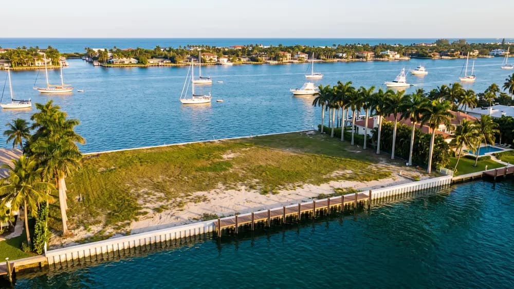 An empty Intracoastal lot with open water and moored boats beyond.