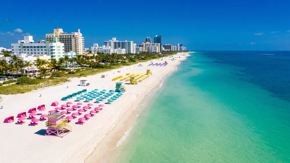 South Beach from above with candy-coloured umbrellas on white sand.